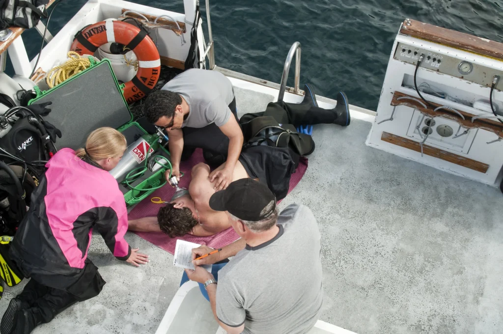 A PADI Instructor teaches an EFR Course on a boat.