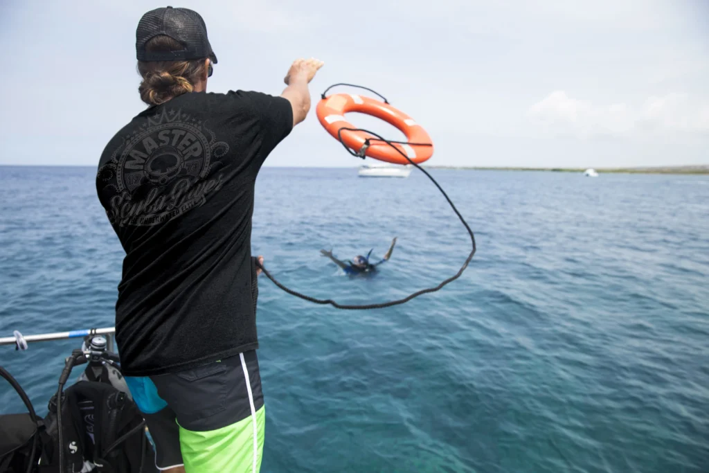 A diver throws a life saver from a boat during a PADI Rescue Diver course.