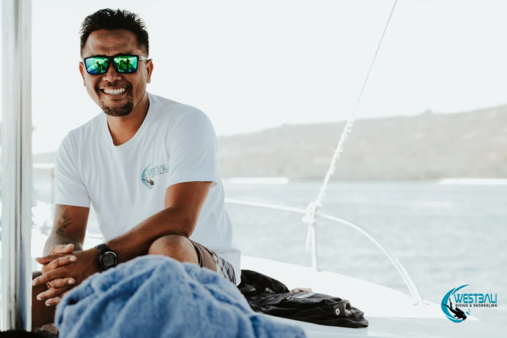 The owner of West Bali Diving & Snorkeling smiles on a dive boat at Menjangan Island in Bali, Indonesia.