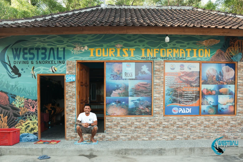 The owner of West Bali Diving & Snorkeling sits in front of the dive center.