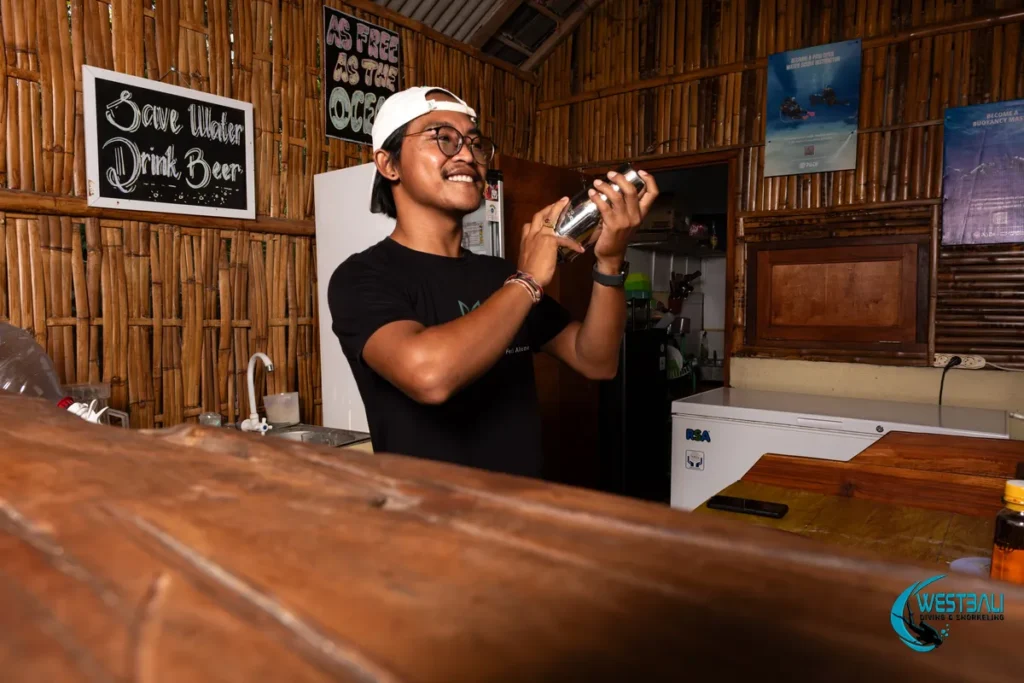 Gede smiles as he shakes a cocktail behind the bar at Krecak Bar & Grill Sumberkima.